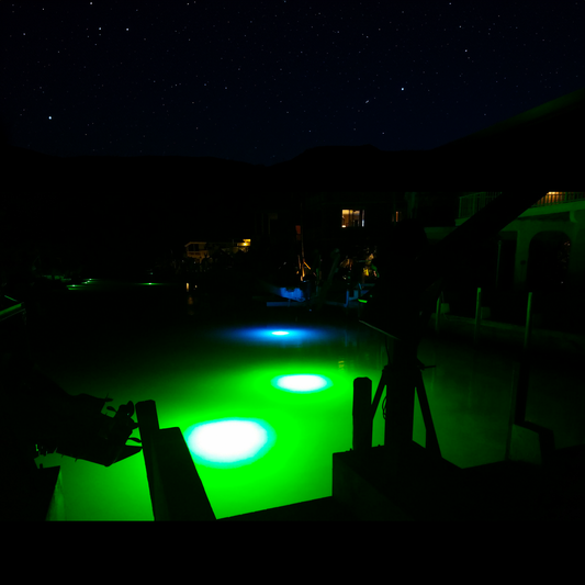 Comparison of green and blue underwater fish lights illuminating a dock at night